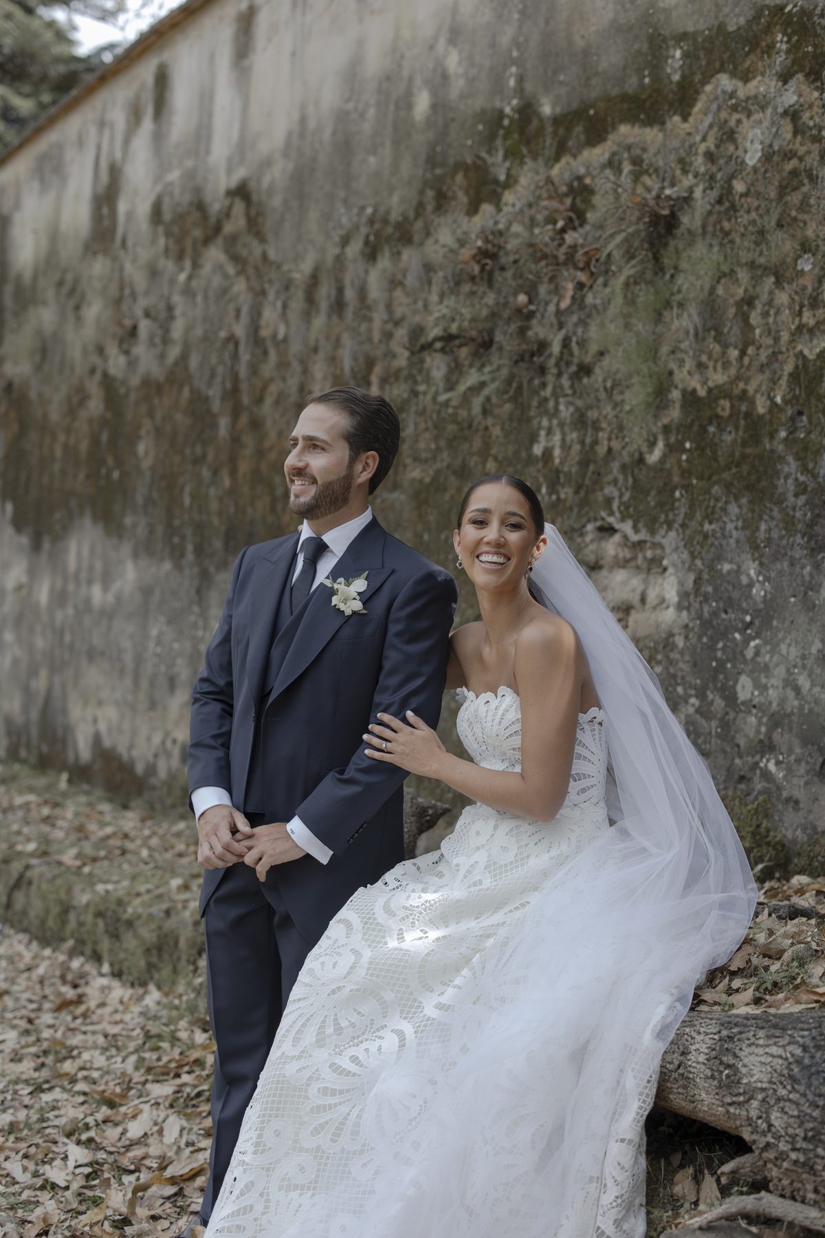 Bride and groom by an old wall